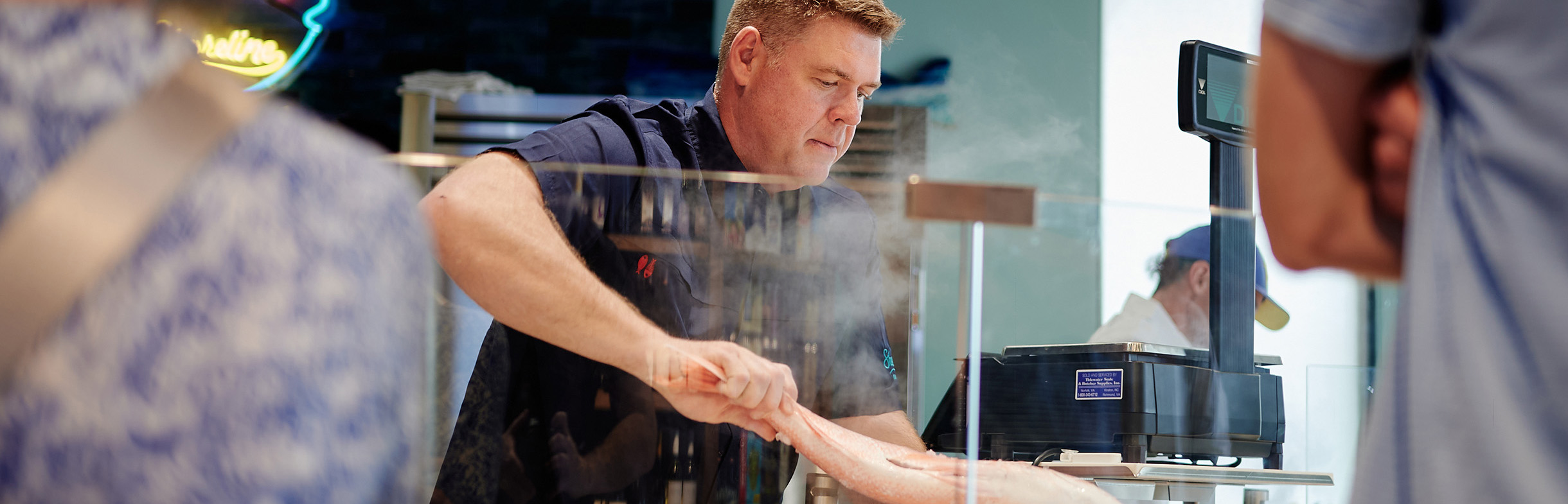 Shoreline Fresh Seafood Market - Photo of owner, David Whitby handling fish at the fresh, reliably sourced seafood case